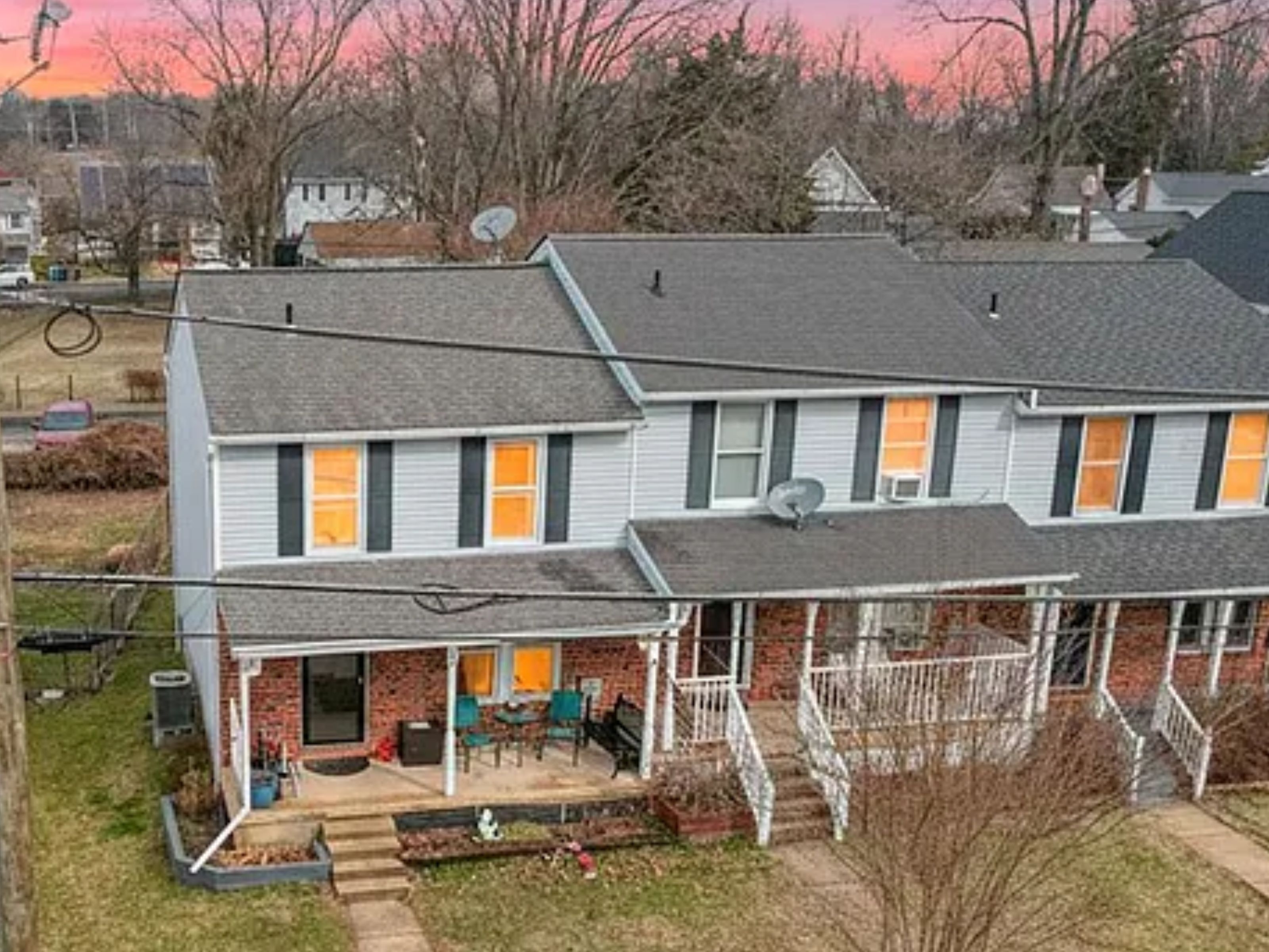 A two-story house with a covered porch and a small front yard.