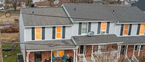 A two-story house with a covered porch and a small front yard.