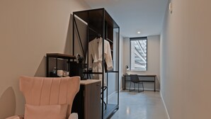 Una habitación moderna con un ventanal grande, un escritorio, una silla y un armario.