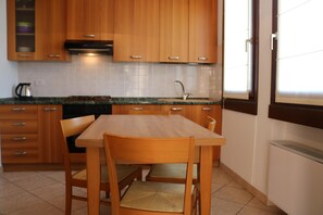A kitchen with wooden cabinets, a countertop, a sink, and a window. - Balcony, Lake View, Walking Distance Lazise Centre (Lazise)