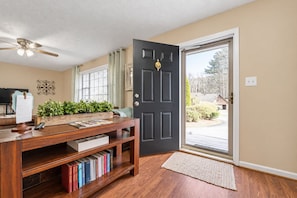 A room with a wooden desk, a bookshelf, a black door, and a view through the door. - Peachtree City Home Near Lake with Yard & Firepit (Peachtree City)