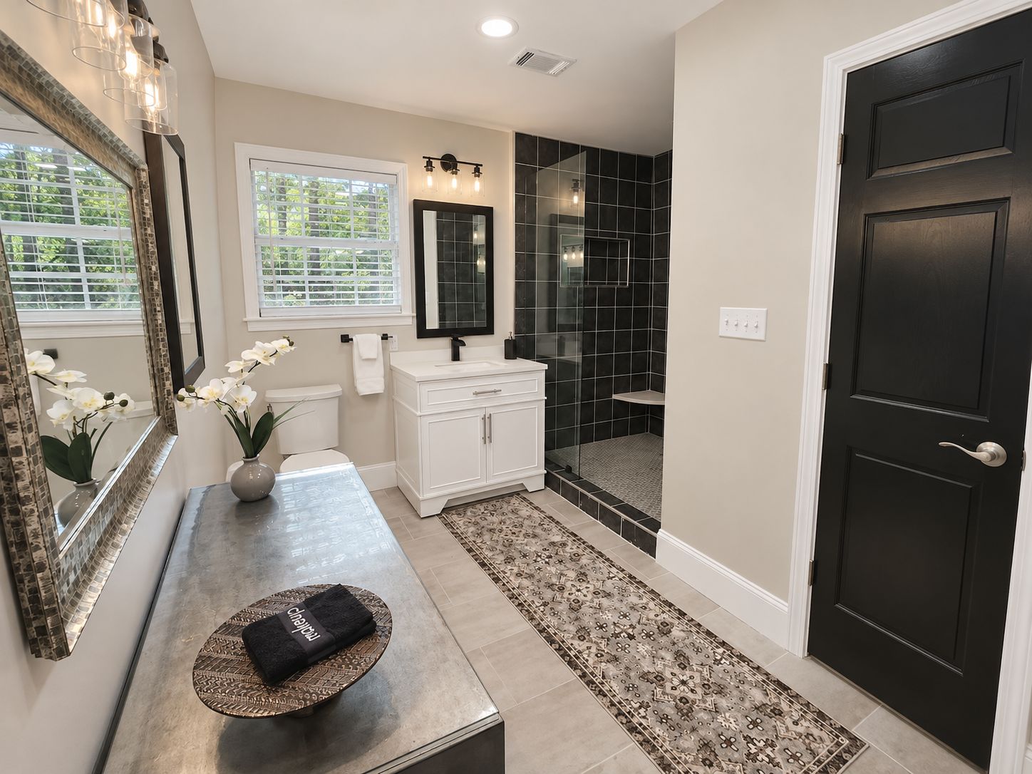 A bathroom with a vanity, mirror, sink, and shower area.