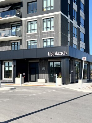 A modern building with a 'highlands' sign, large windows, and a parking lot.