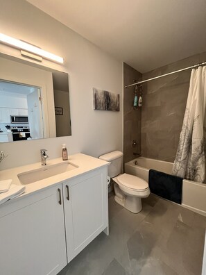 A modern bathroom with a sink, toilet, and bathtub.