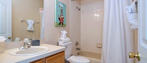 A bathroom with a sink, toilet, and shower.