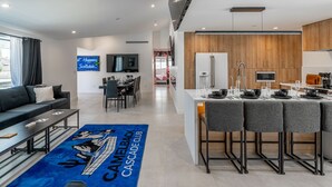 Une chambre d’hôtel moderne dotée d’un coin repas, d’une cuisine et d’une grande fenêtre.