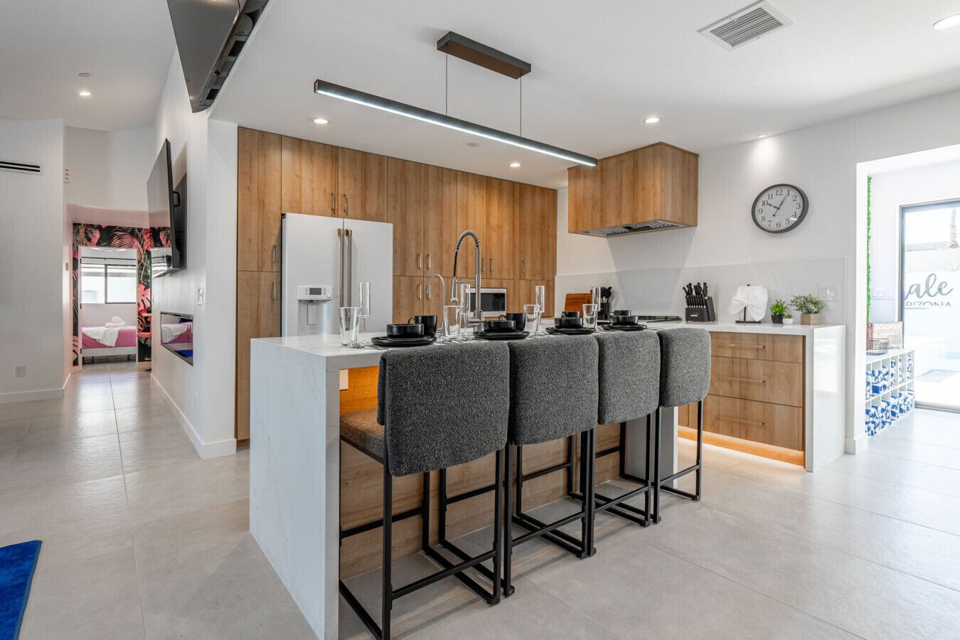 A modern kitchen with a central island, wooden cabinets, and a built-in microwave.