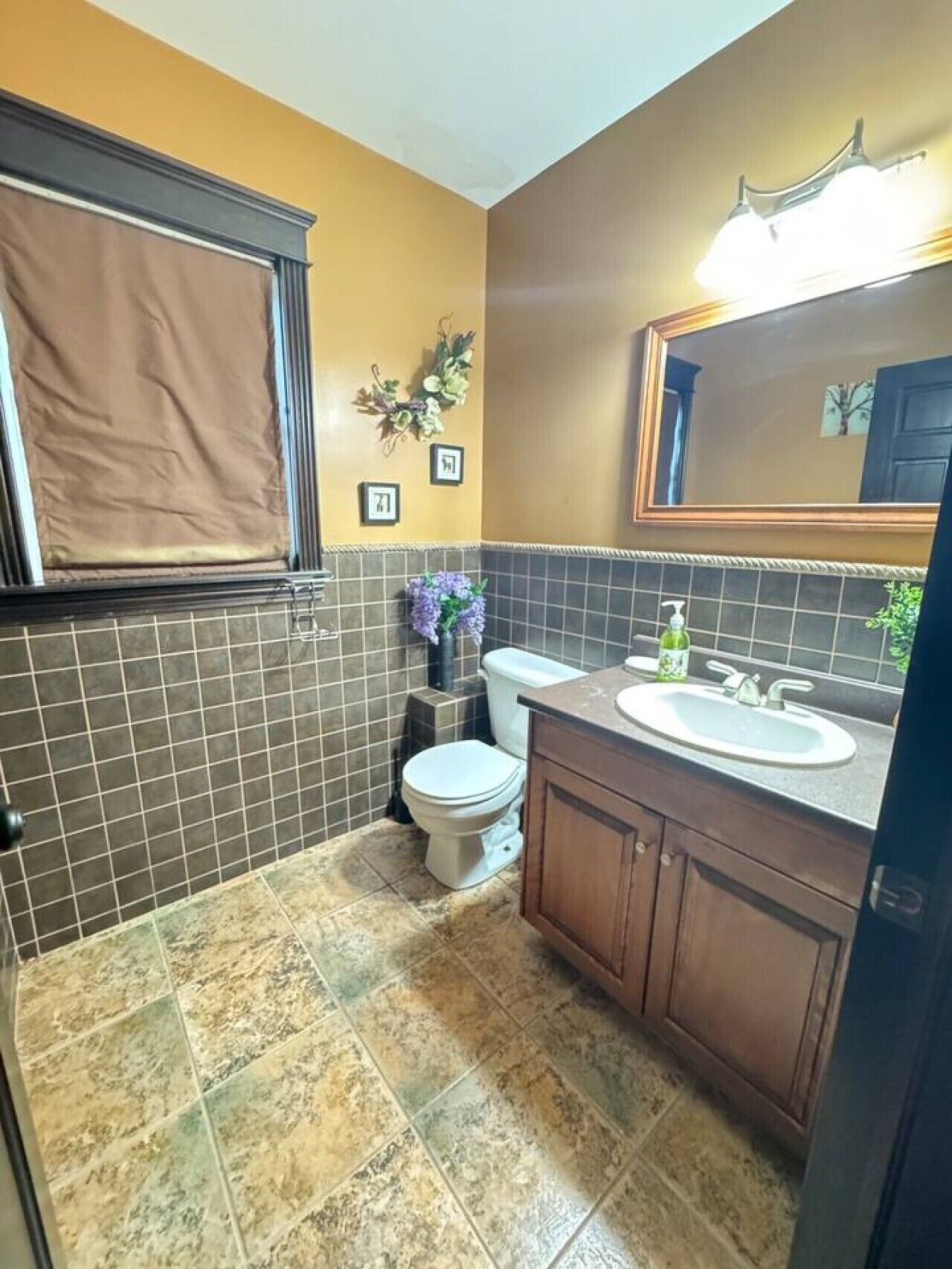 Un baño con inodoro, lavamanos y espejo.