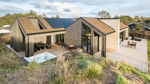 A modern house with a deck, a hot tub, and a large window. - "Uschi" - 1km from the sea by Interhome (Blokhus)