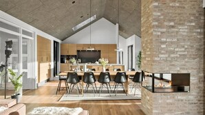 A modern kitchen with a dining area, a fireplace, and a large TV. - "Uschi" - 1km from the sea by Interhome (Blokhus)