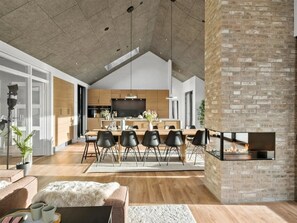 Eine moderne Küche mit Essbereich, Kamin und großem Fernseher.