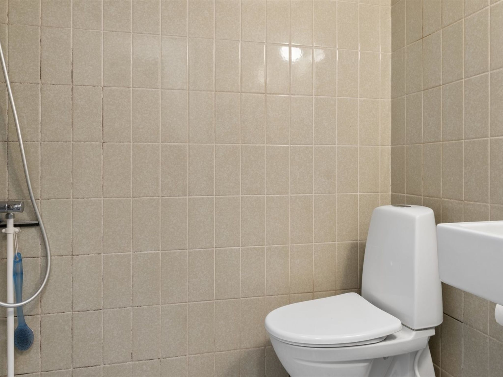 Un baño con inodoro, ducha y secador de manos.