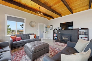 A living room with a fireplace, a sofa, a coffee table, and a television.
