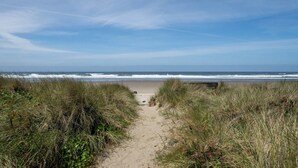 A beach path leading to the ocean with grassy dunes on either side. - #StayInMyDistrict Strandhuisje Oceanview Retreat (Rockaway Beach)