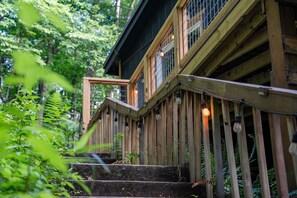 A wooden staircase leading to a building with multiple windows and a railing. - Forest Cottage w Fire Pit Near Cashiers! (Cashiers)
