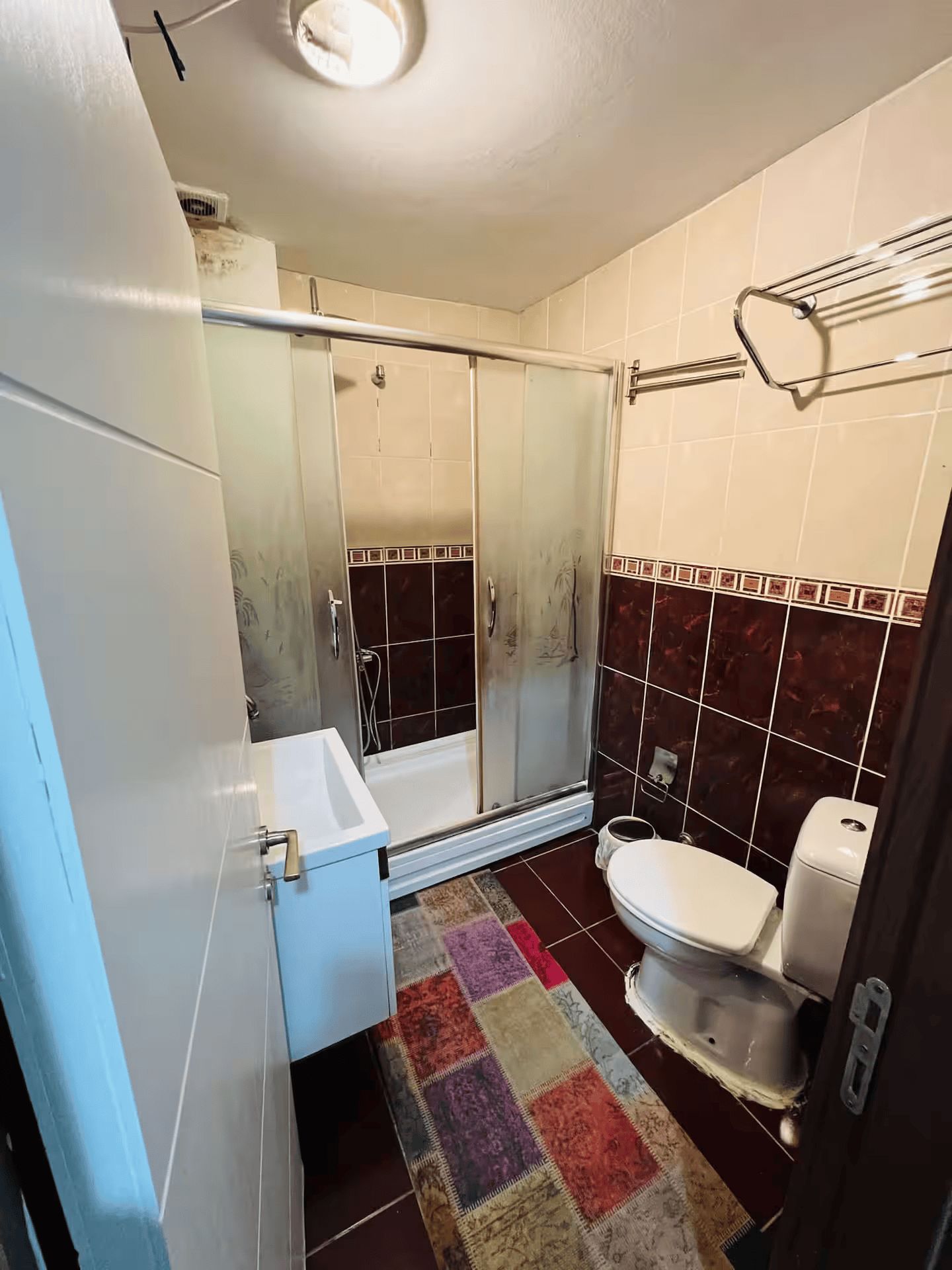 A bathroom with a shower, toilet, and sink.