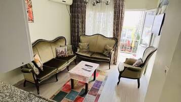 A living room with a sofa set, a coffee table, and a TV.