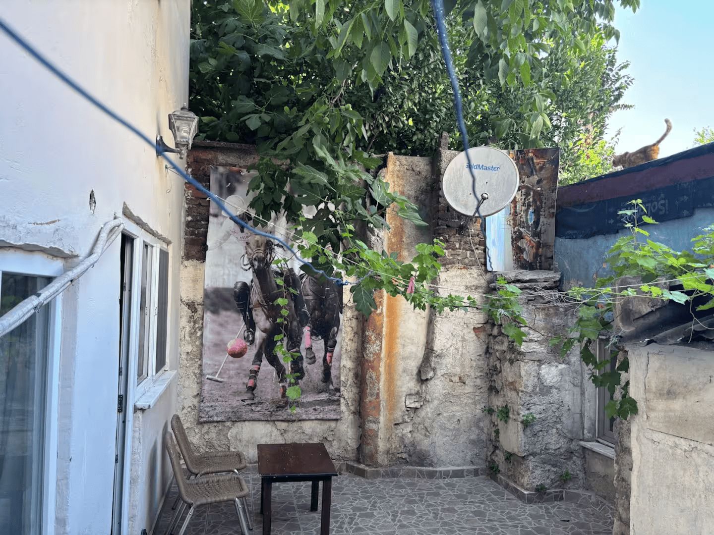 A courtyard with a satellite dish, a small table, and a chair.