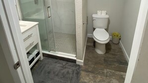 Ein Badezimmer mit einer Duschkabine, einer Toilette und einem Waschbecken mit Waschtisch.