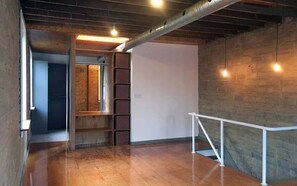 Ein Innenraum mit Holzboden, weißer Wand und einer Metallduct an der Decke.