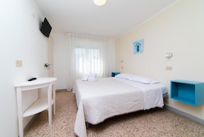 A hotel room with a bed, a desk, a TV mounted on the wall, and a window with curtains. - Hotel 21 (Riccione)