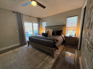 A bedroom with a bed, a ceiling fan, a nightstand, and a window. - Beautifully Remodeled Pool Home in Southern Dunes (Haines City)