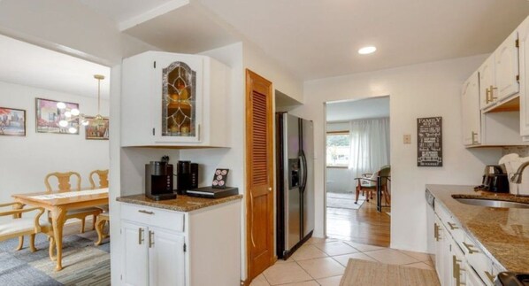 A modern kitchen with white cabinets, a built-in oven, and a refrigerator.