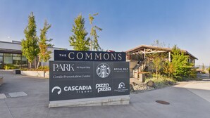 Een bord voor The Commons Park met logo's van Cascadia Liquor, Pizza Pizza, Royal Bay Dental Co. en Creative Horizons Counselling.