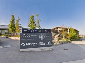 Schild für The Commons Park mit Logos von Cascadia Liquor, Pizza Pizza, Royal Bay Dental Co. und Creative Horizons Counselling.