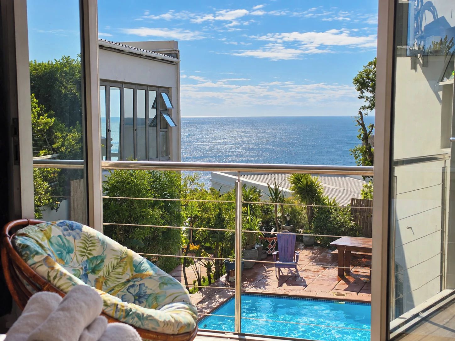Ein Balkon mit Meerblick, ein Schwimmbad und ein Stuhl.