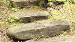 A stone staircase in a forested area with moss-covered steps and a wooden post. - The Shire Hobbit House is a 1-bedroom with AC in charming Flat Rock, Alabama. (Flat Rock)