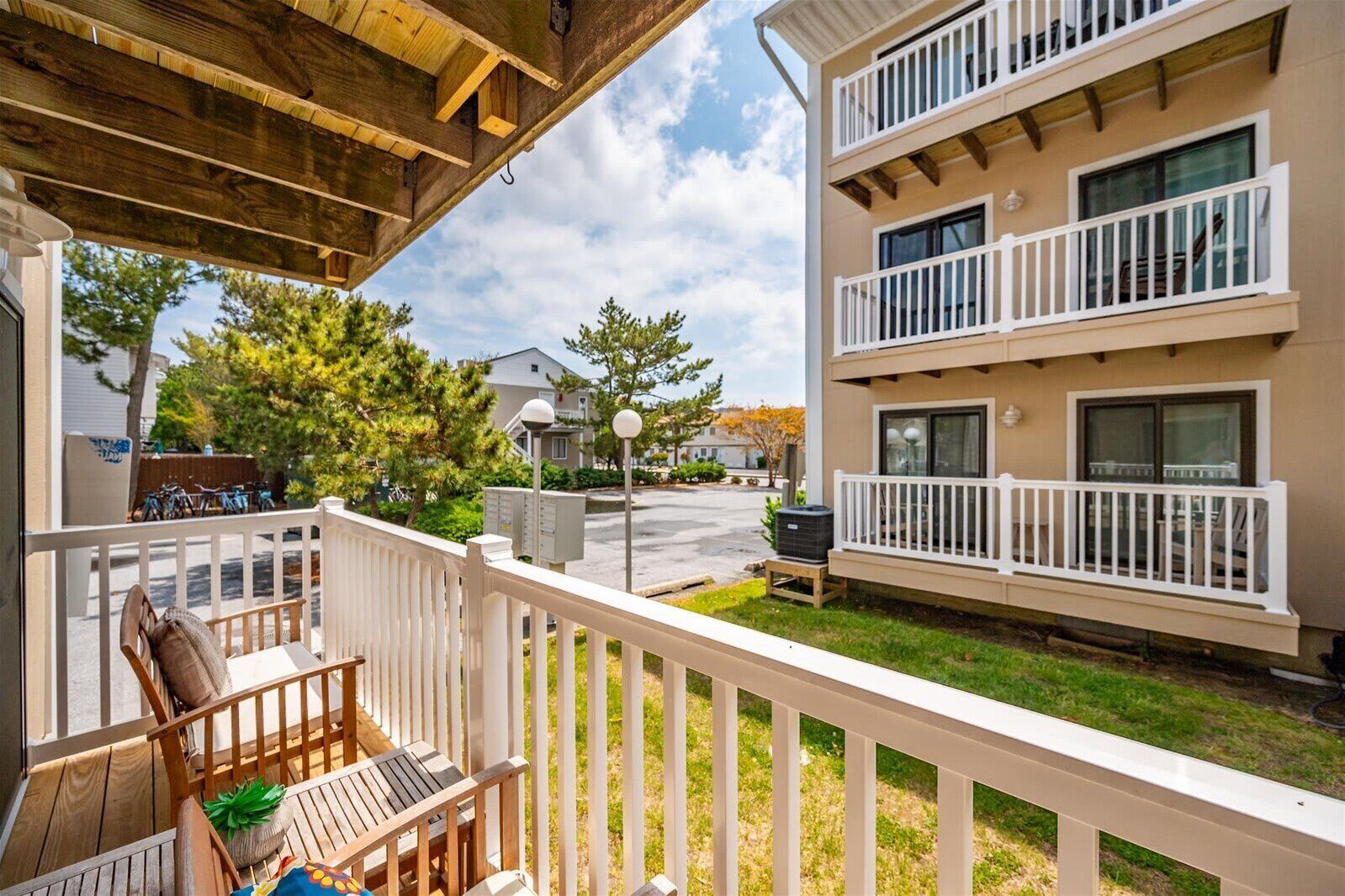 A residential building with a balcony, outdoor seating, and a clear view of the surrounding neighborhood.
