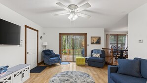 A living room with a ceiling fan, a flat-screen TV, a sofa, a coffee table, and a dining area with a table and chairs. - 1.5 Miles to Kennebunk BEACH|Sleeps 12| Pet friendly (Kennebunk)