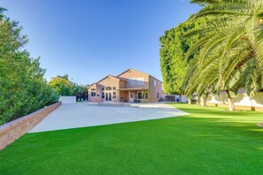 A two-story house with a front porch, a driveway, and a well-maintained lawn. - Upscale Chandler Executive Home | Resort Backyard (Chandler)