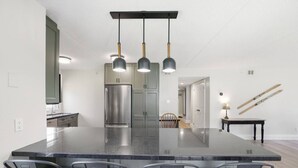 A modern kitchen with a large island, stainless steel appliances, and pendant lighting. - Rustic-Modern Gem | Steps to Blue Mtn Village (The Blue Mountains)