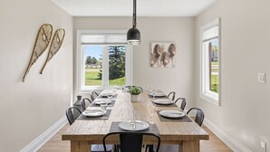 A dining room with a wooden table, chairs, and a hanging light fixture. - Rustic-Modern Gem | Steps to Blue Mtn Village (The Blue Mountains)