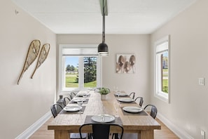 Ein Esszimmer mit Holztisch, Stühlen und einer Hängelampe.