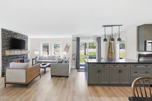 A modern kitchen with grey cabinets, a built-in oven, and a large island.