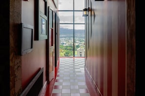 Ein Korridor mit Schachbrettboden, Blick durch eine Glastür und einer Wandleuchte.