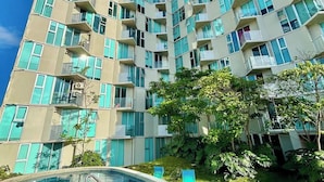 Un edificio residencial alto con piscina y área de estar al aire libre.