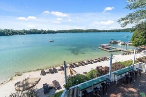 Une vue sur le lac, avec un quai, des chaises longues et une terrasse.