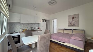 A compact bedroom with a bed, a small desk, and a kitchenette. - Relax and enjoy the amazing view! Great for family, couple od single travelers! (Bar)