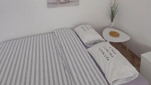 A bedroom with a bed, a small round table, a potted plant, and a wall-mounted picture. - Relax and enjoy the amazing view! Great for family, couple od single travelers! (Bar)