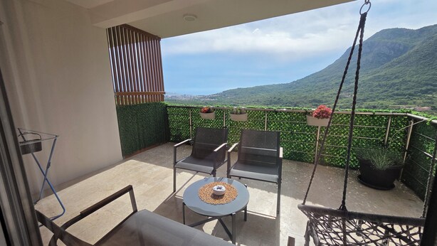 A balcony with two chairs, a small table, and a hanging chair. - Relax and enjoy the amazing view! Great for family, couple od single travelers! (Bar)