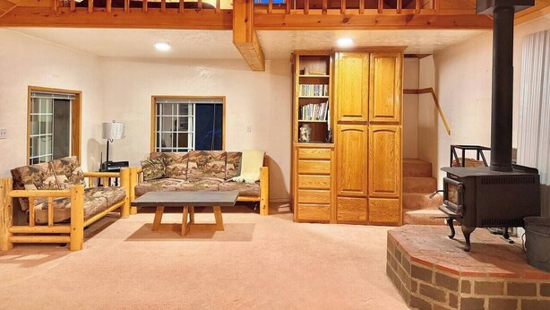 A cozy living room with a sofa, a wooden cabinet, and a fireplace.