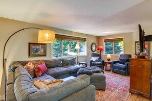 A living room with a sectional sofa, a chair, a lamp, and a television.