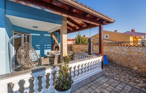 A patio with outdoor furniture, a stone wall, and a hanging decorative item. - Beautiful home in Vodnjan (Vodnjan)
