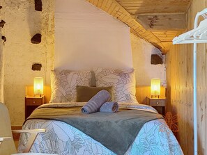 Ein gemütliches Zimmer mit einem Bett, zwei Nachttischlampen und einer Holzzahl.