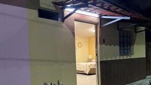 Een kamer met een bed, een nachtkastje en een raam.