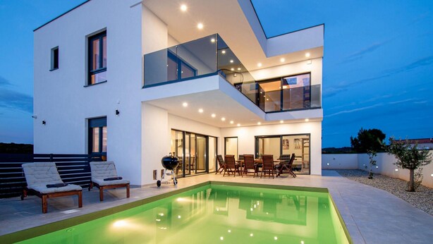 A modern two-story house with a swimming pool, outdoor seating, and a balcony. - Gorgeous home in Medulin (Medulin)